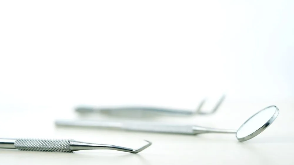 Basic dentist tools laid out on a white surface — dental clinic in Buderim, QLD