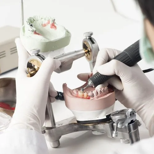 Dental technician working with an articulator in the dental laboratory — dental clinic in Maroochydore, QLD