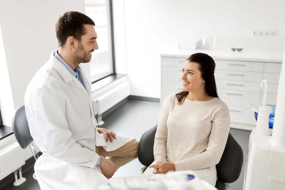 Male dentist talking with a female patient in the clinic — dental clinic in Mooloolaba, QLD