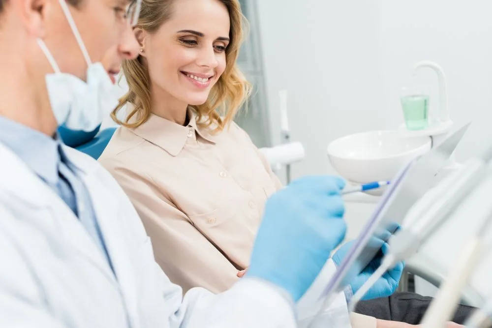 Dentist recording a diagnosis while consulting with a patient in a modern dental clinic — dental clinic in Buderim, QLD