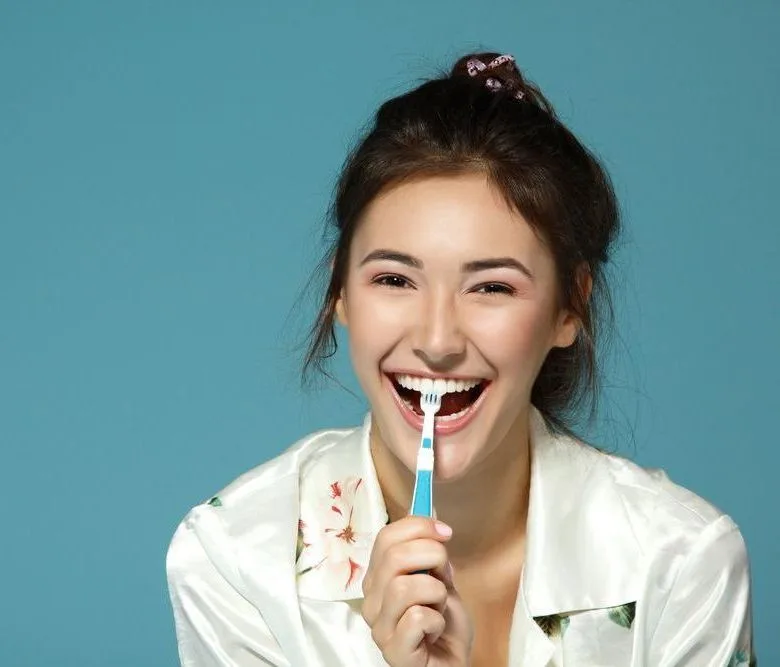 Happy woman brushing her teeth — dental clinic in Mooloolaba, QLD