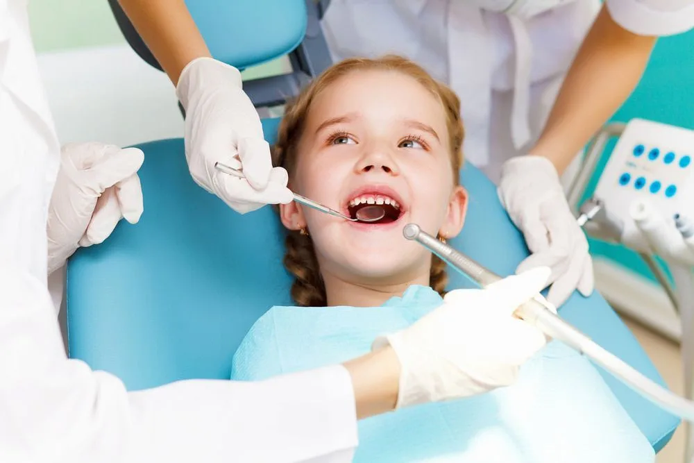 Little girl having a dental check-up with the dentist and nurse — dental clinic in Buderim, QLD