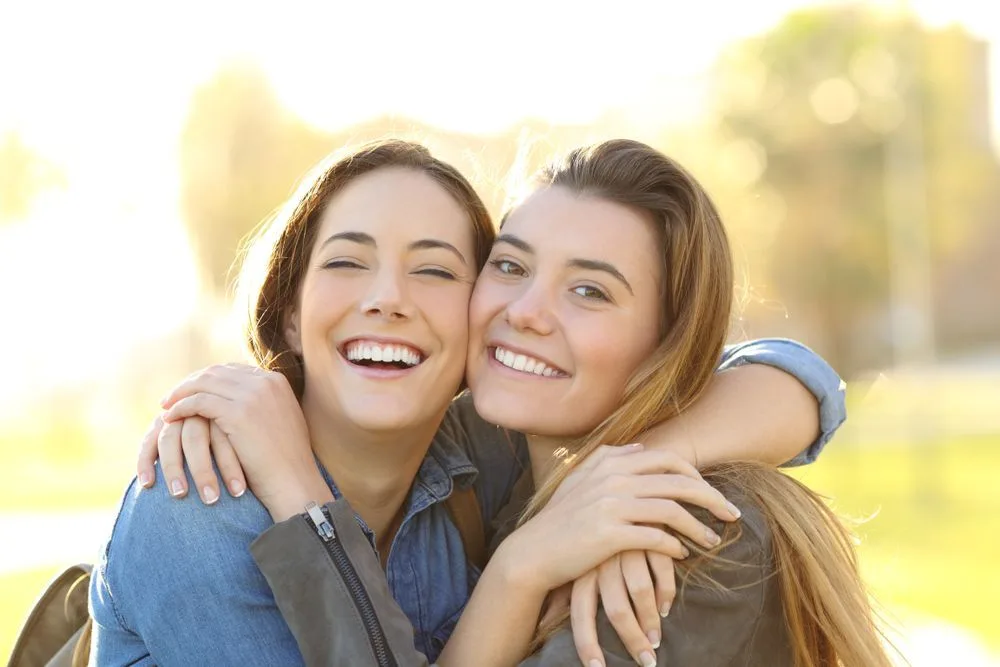 Two friends smiling together outdoors — dental clinic in Buderim, QLD